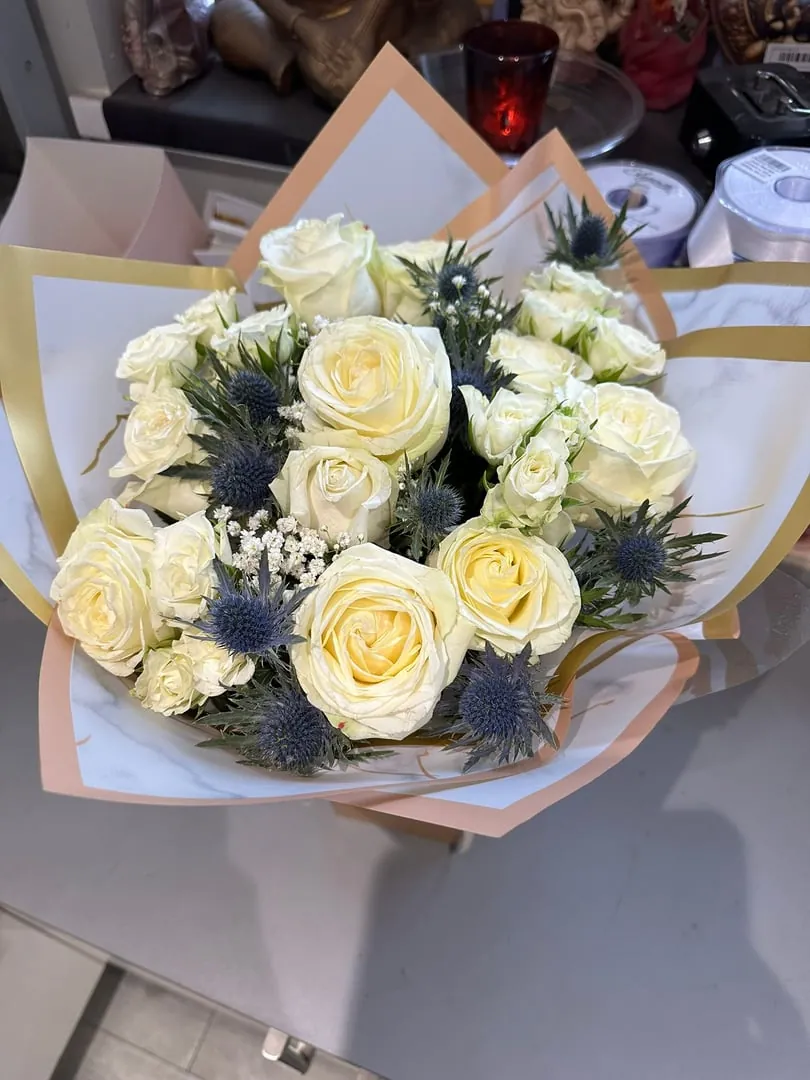 Cream roses with blue thistle