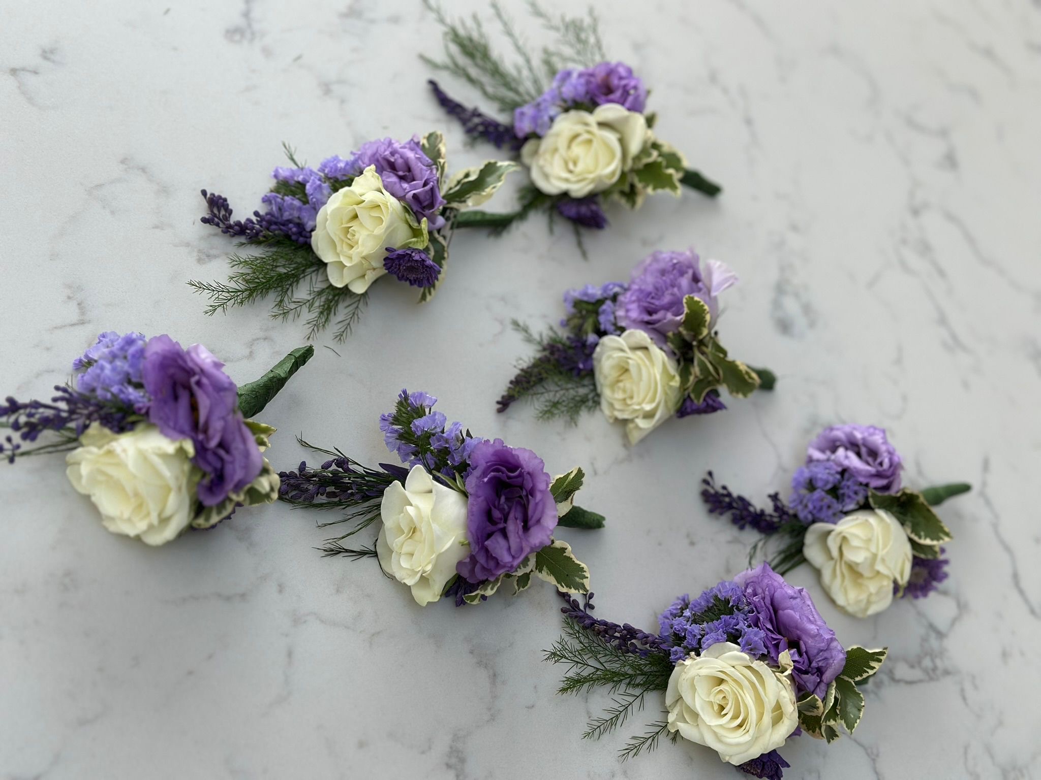 Purple and white buttonholes for the wedding party